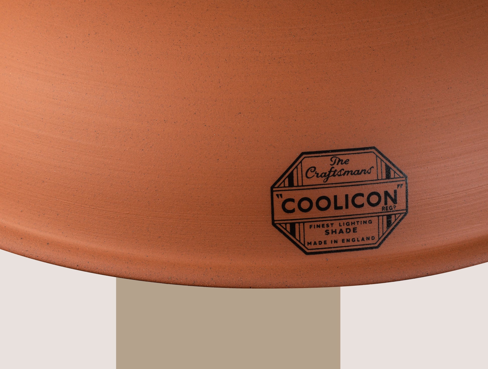 A close up of the front of a Natural Terracotta shade, showing the details of the badge as well as the texture on the shade