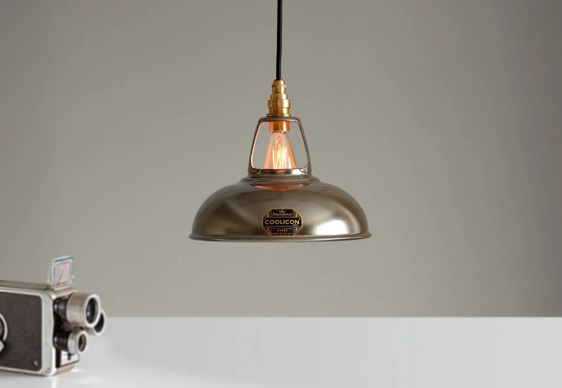 An Original Antinium shade hanging over a table above an old film camera
