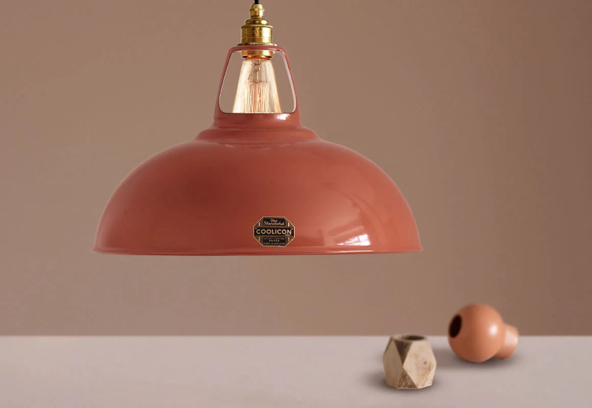 A Large Coolicon Terracotta lampshade hanging over a small orange flower vase and a small wooden vase