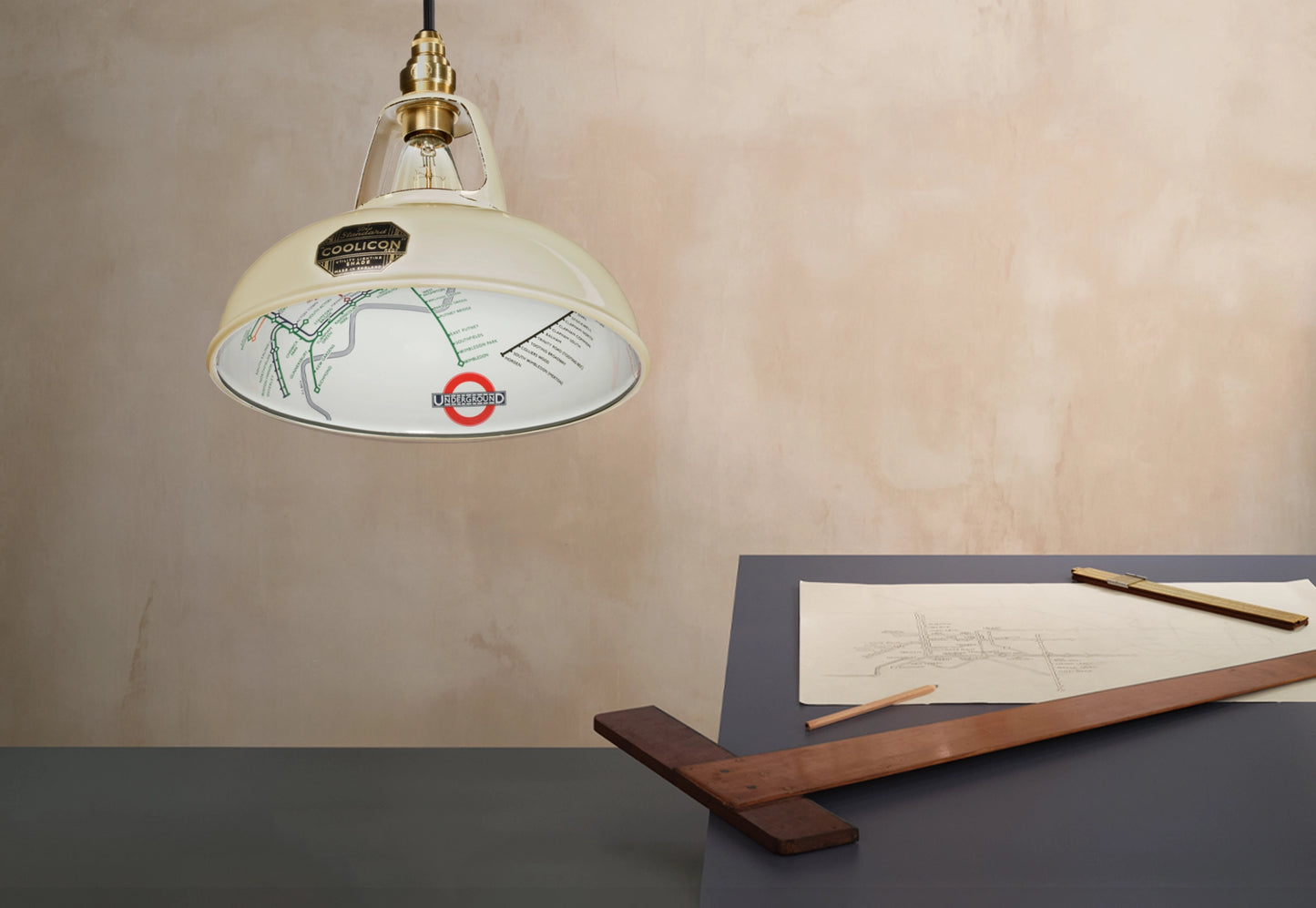 An Original Paper Cream shade over a table. There is a T-square ruler underneath and a pencil sketch of the London Underground map