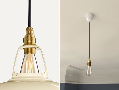 Close up of an E14 Signature Brass suspension set on a Classic Cream lampshade on the left. On the right, an E14 Brass pendant set with a lightbulb is hanging from the ceiling