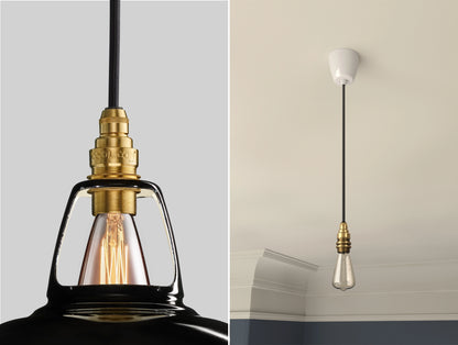 Close up of an E14 Brass suspension set on a Northern Line Black shade on the left. On the right, an E14 Brass pendant set with a lightbulb is hanging from the ceiling 