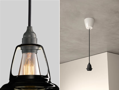 Close up of an E27 Industrial suspension set on a Jet Black lampshade on the left. On the right, an E27 Industrial pendant set is hanging from the ceiling