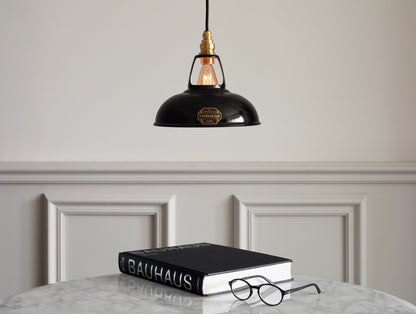 An Original Jet Black shade hanging over a table above a large black Bauhaus book and a pair of round black glasses.