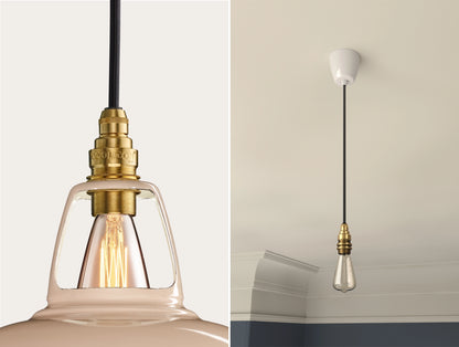 Close up of an E14 Signature Brass suspension set on a Latte Brown lampshade on the left. On the right, an E14 Brass pendant set with a lightbulb is hanging from the ceiling