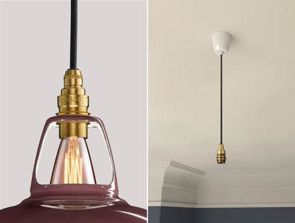 Close up of an E14 Signature Brass suspension set on a Metropolitan lampshade on the left. On the right, an E14 Brass pendant set is hanging from the ceiling