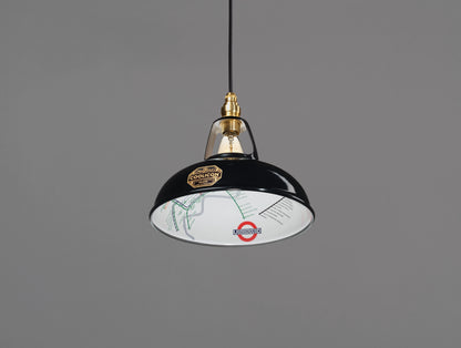 An Original Northern Line Black shade hanging over a grey background