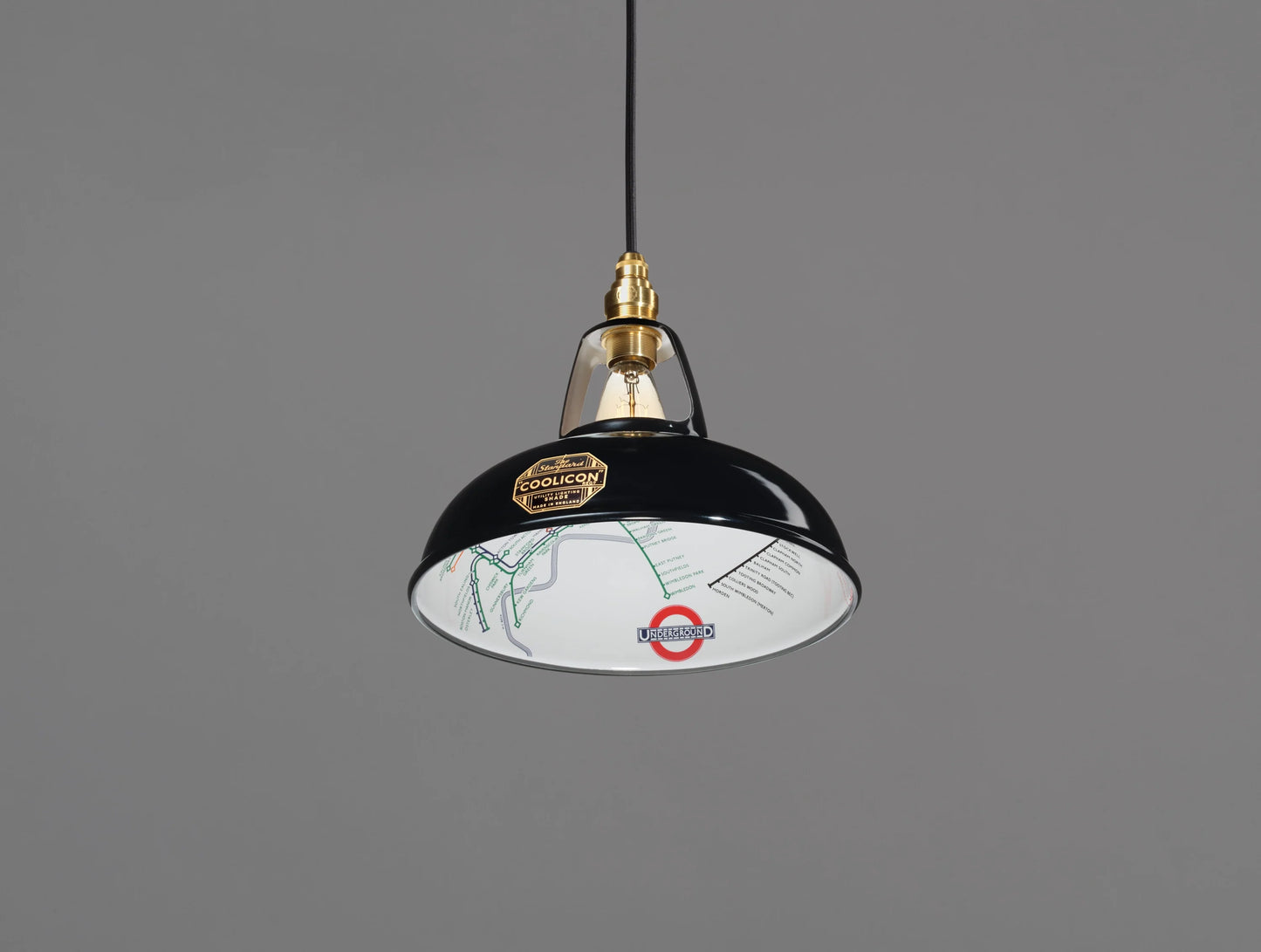 An Original Northern Line Black shade hanging over a grey background