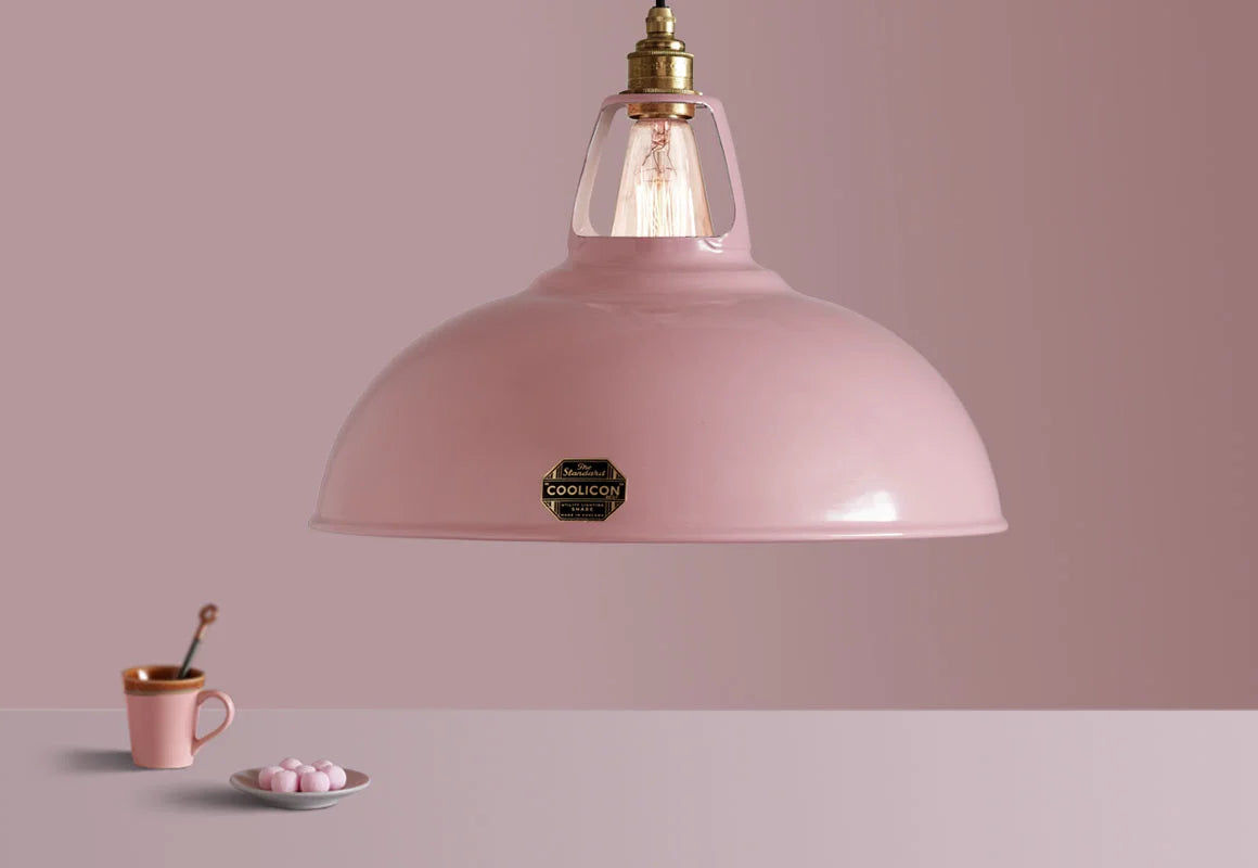 A Coolicon Powder Pink lampshade with a Brass pendant set hanging above a table with a pink coffee cup and pink sweets