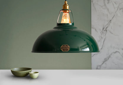 A Large Coolicon Original Green lampshade hanging over a table with two green bowls