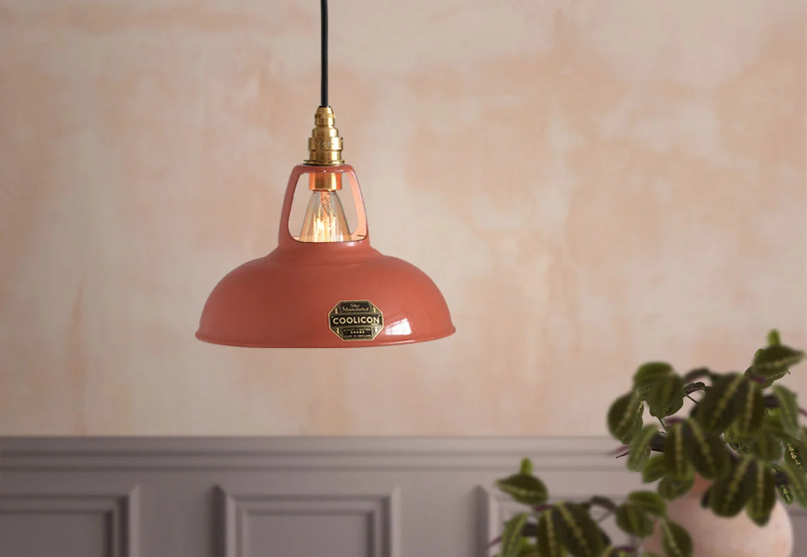 Terracotta Coolicon lampshade with a Brass pendant set hanging in front of an orange textured wall