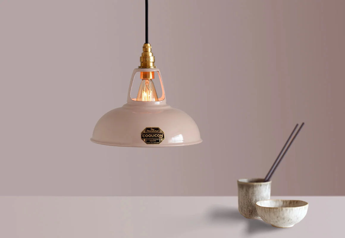 A Coolicon Latte Brown lampshade with a Signature Brass pendant set hanging above a table with a bowl, a cup and chopsticks