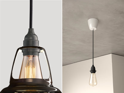 Close up of an E27 Industrial suspension set on a Pewter lampshade on the left. On the right, an E27 Industrial pendant set with a lightbulb is hanging from the ceiling