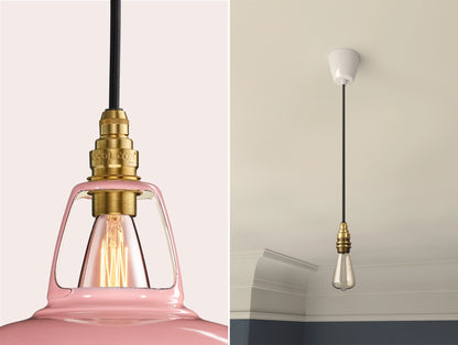 Close up of an E14 Signature Brass suspension set on a Powder Pink lampshade on the left. On the right, an E14 Brass pendant set with a lightbulb is hanging from the ceiling