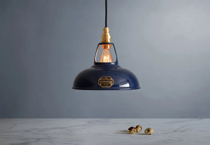 An Original Royal Blue shade hanging over a marble table with quail eggs