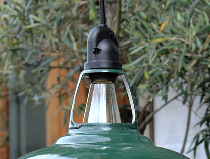 Green Coolicon Pendant lampshade with an IP65 water-resistant fitting and black over braided fabric cable in front of green olive garden tree