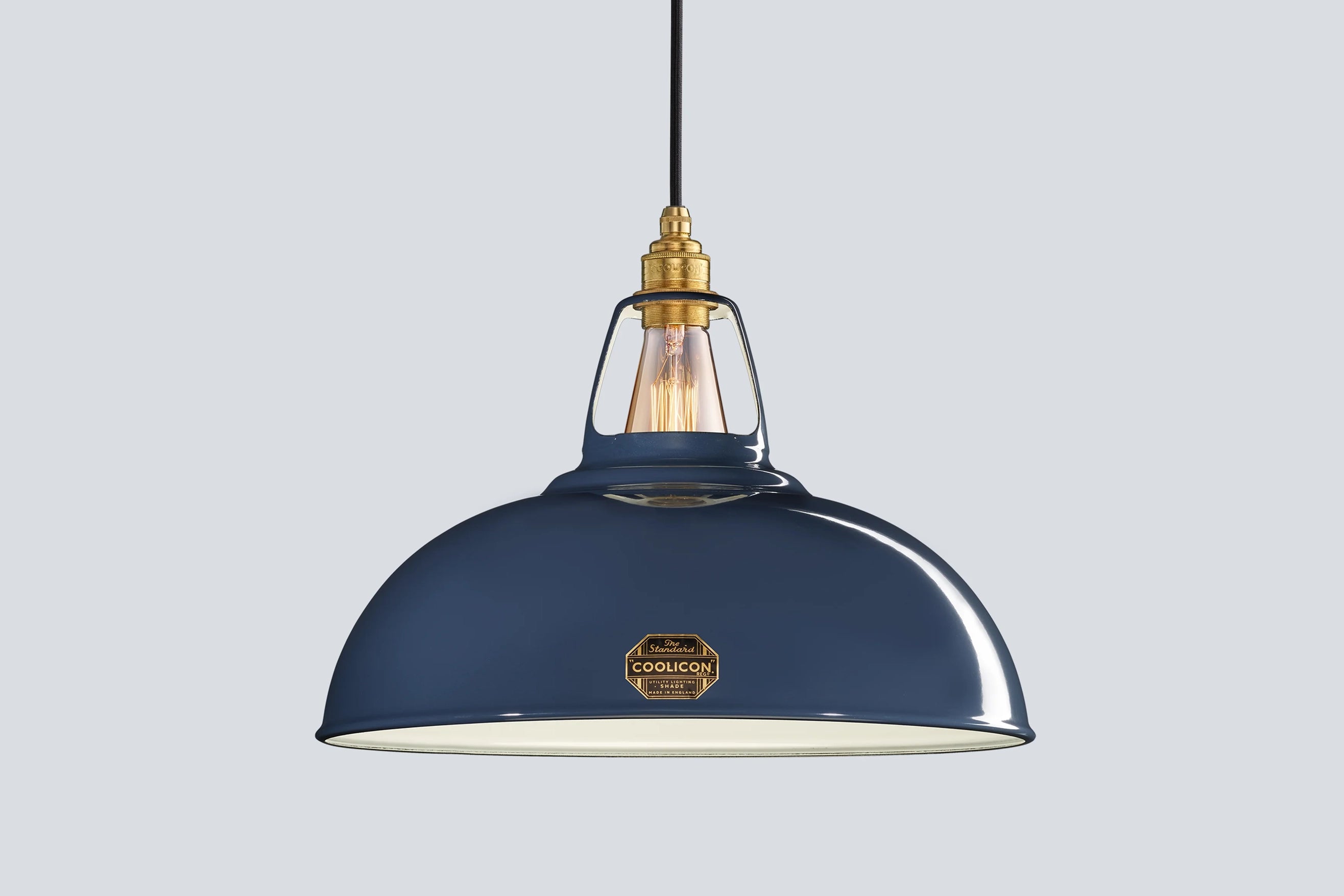 Large Selvedge blue Coolicon lampshade with a Signature Brass pendant set over a light blue background