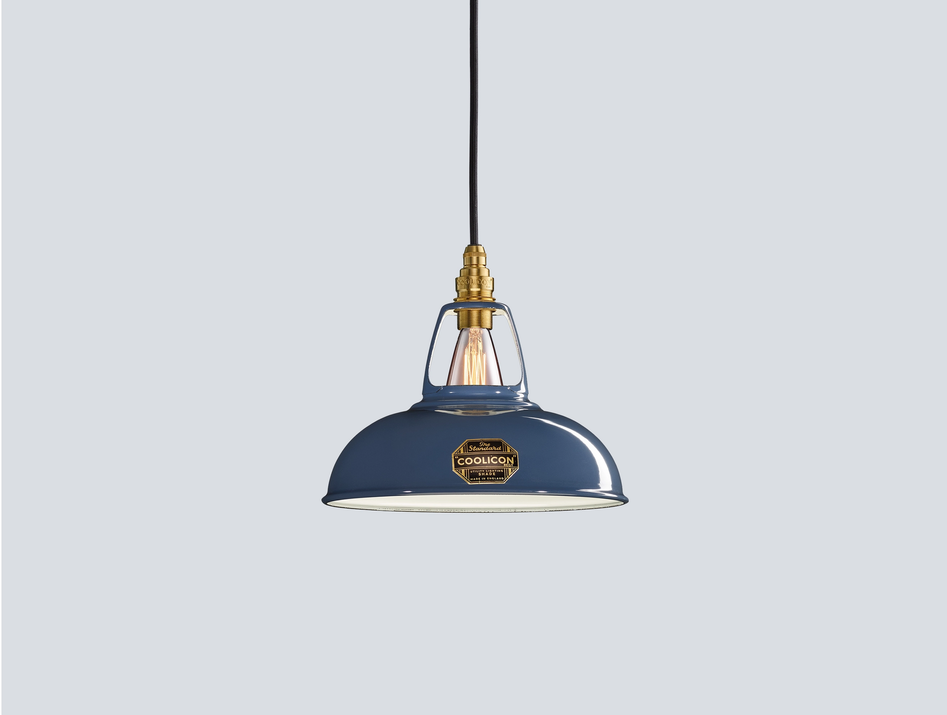 Selvedge blue Coolicon lampshade with a Signature Brass pendant set over a light blue background