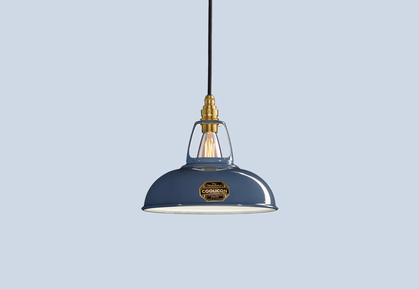 Selvedge blue Coolicon lampshade with a Signature Brass pendant set over a light blue background