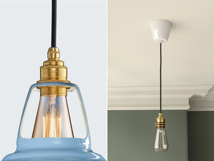 Close up of an E27 Signature Brass suspension set on a Sky Blue lampshade on the left. On the right, an E27 Brass pendant set with a lightbulb is hanging from the ceiling