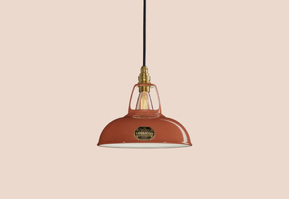 Terracotta Coolicon lampshade with a Brass pendant set over a light teal background