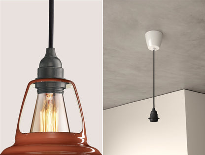 Close up of an E27 Industrial suspension set on a Terracotta lampshade on the left. On the right, an E27 Industrial pendant set is hanging from the ceiling
