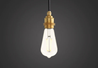 E27 LED Lightbulb hanging over a dark background. The lightbulb is fitted with a Coolicon Brass Suspension Set