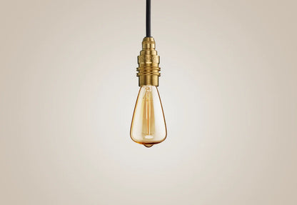 E14 decorative Lightbulb hanging over a light background. The lightbulb is fitted with a Coolicon Brass Suspension Set