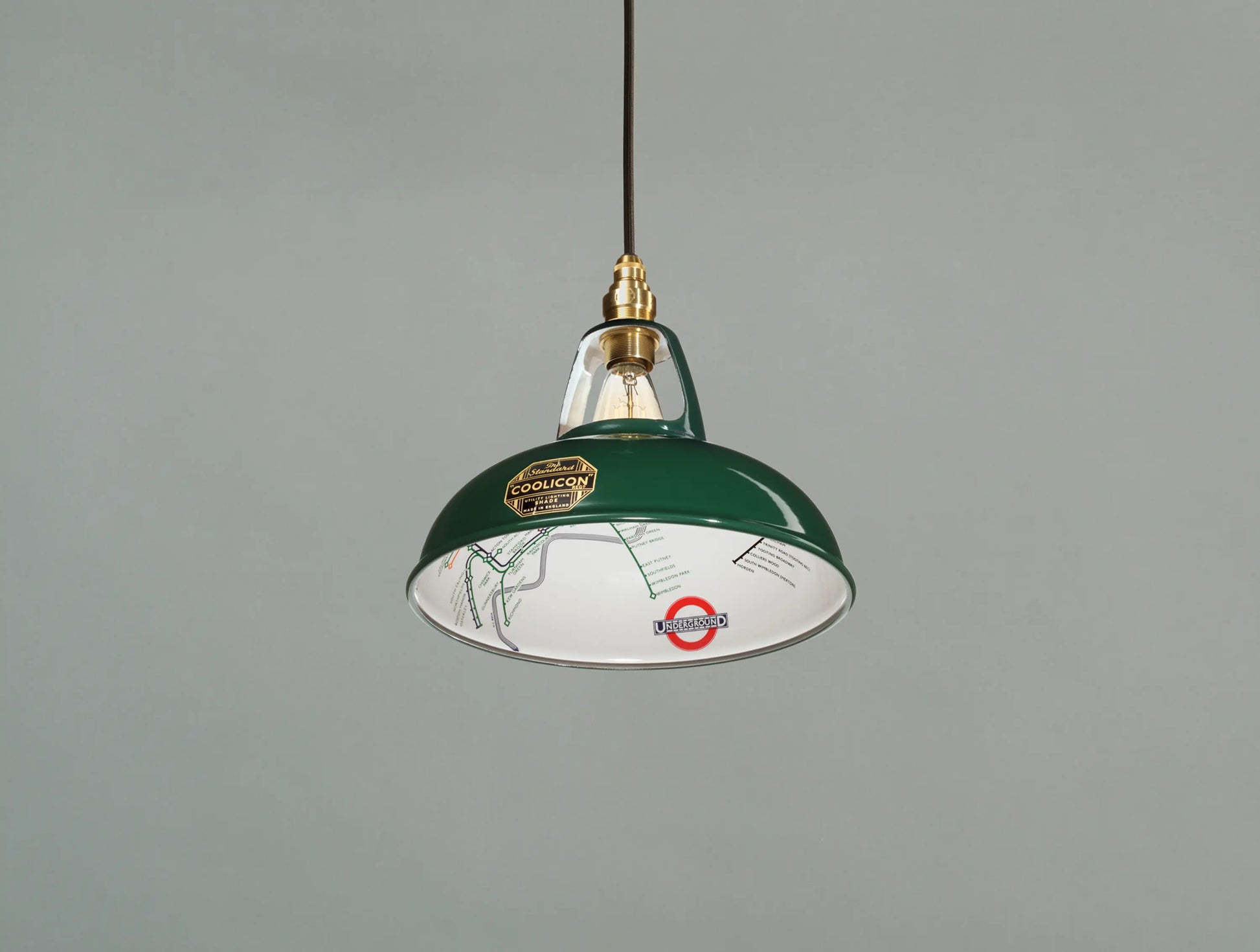 An Original District Line Green shade hanging over a light green background