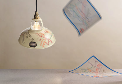 An Original Underground Map shade hanging over a table. In the background, two 1933 maps are falling from the ceiling