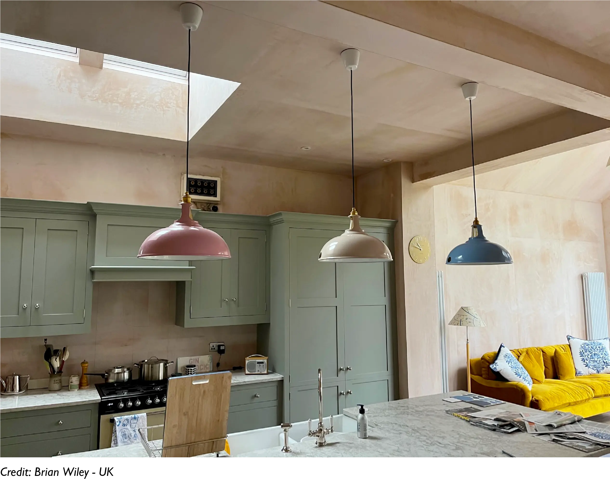 Three Large Coolicon lampshades hang over a kitchen counter