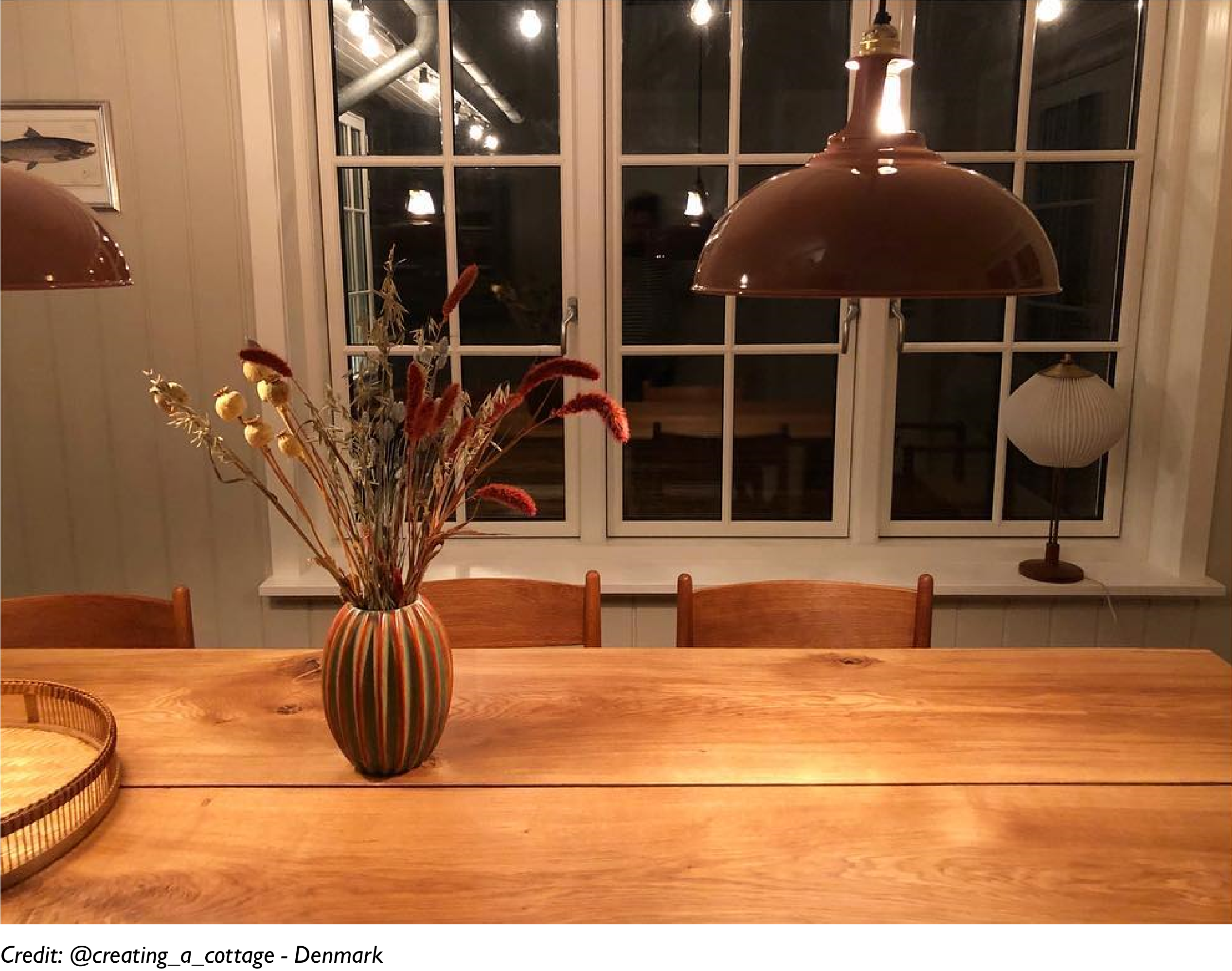 Two Terracotta lamps are suspended over a wooden dining table