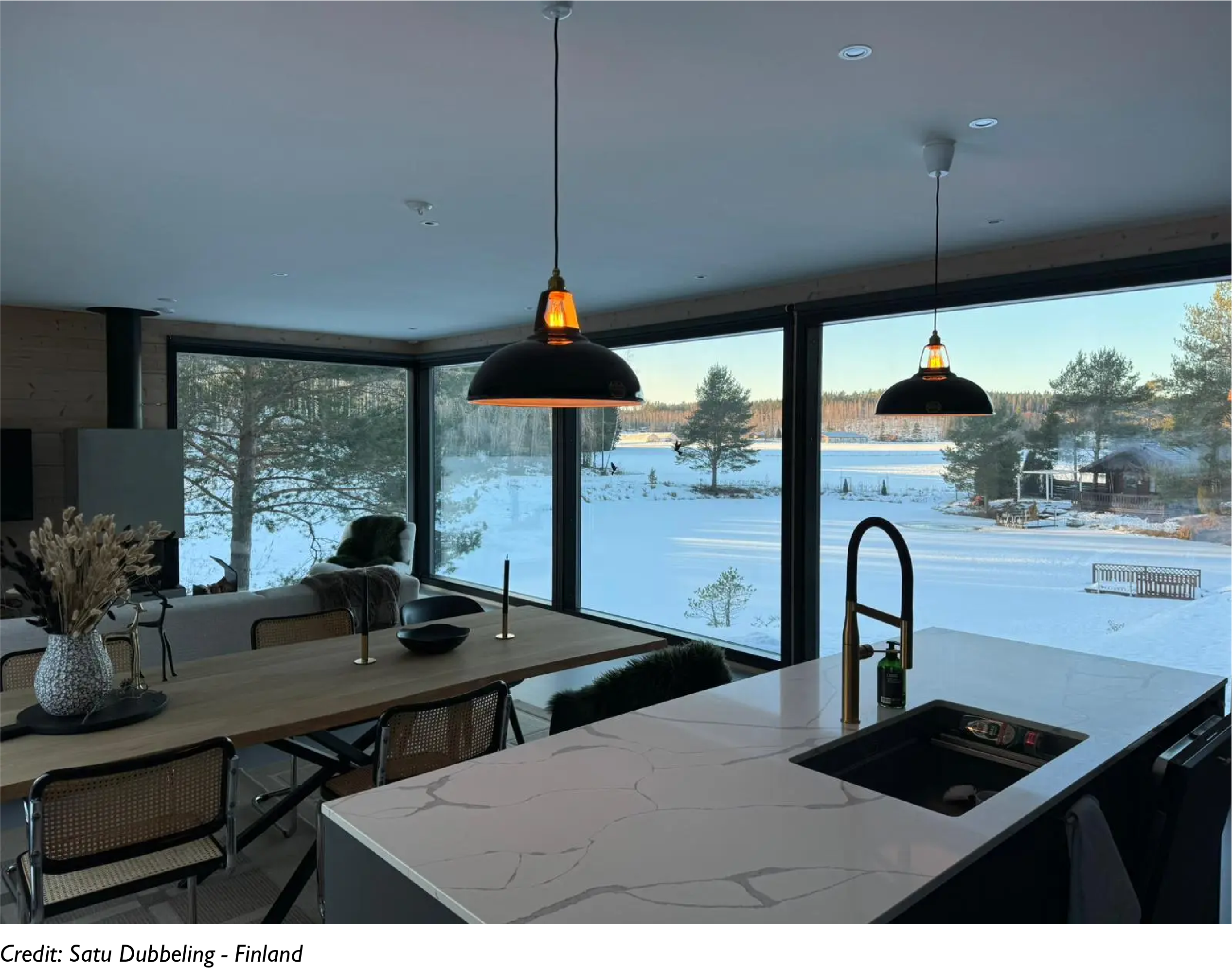 2 Large Jet Black Coolicon lamps hang over a marble kitchen island and a sink