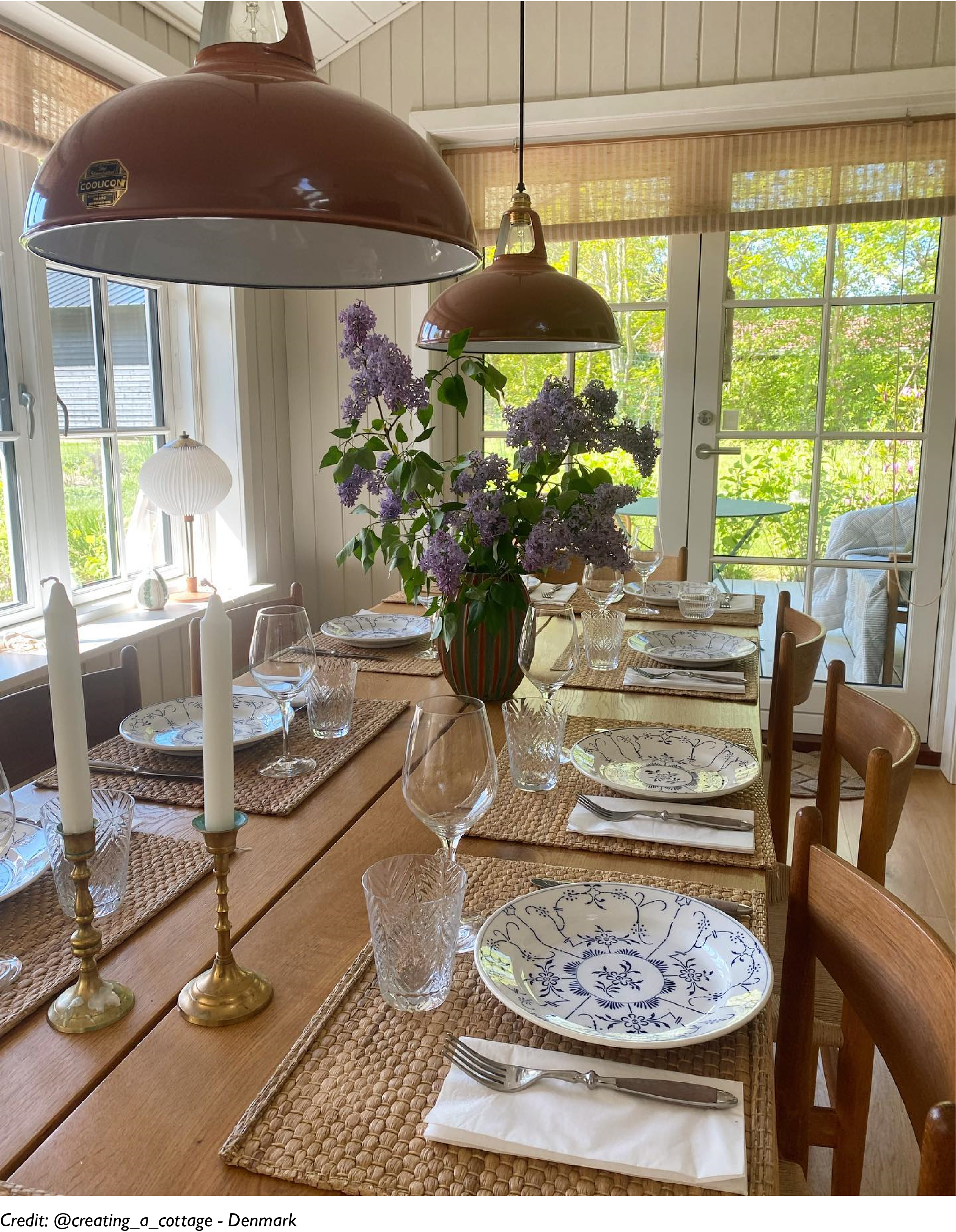 Two Large orange lamps illuminate a breakfast table with eight plates