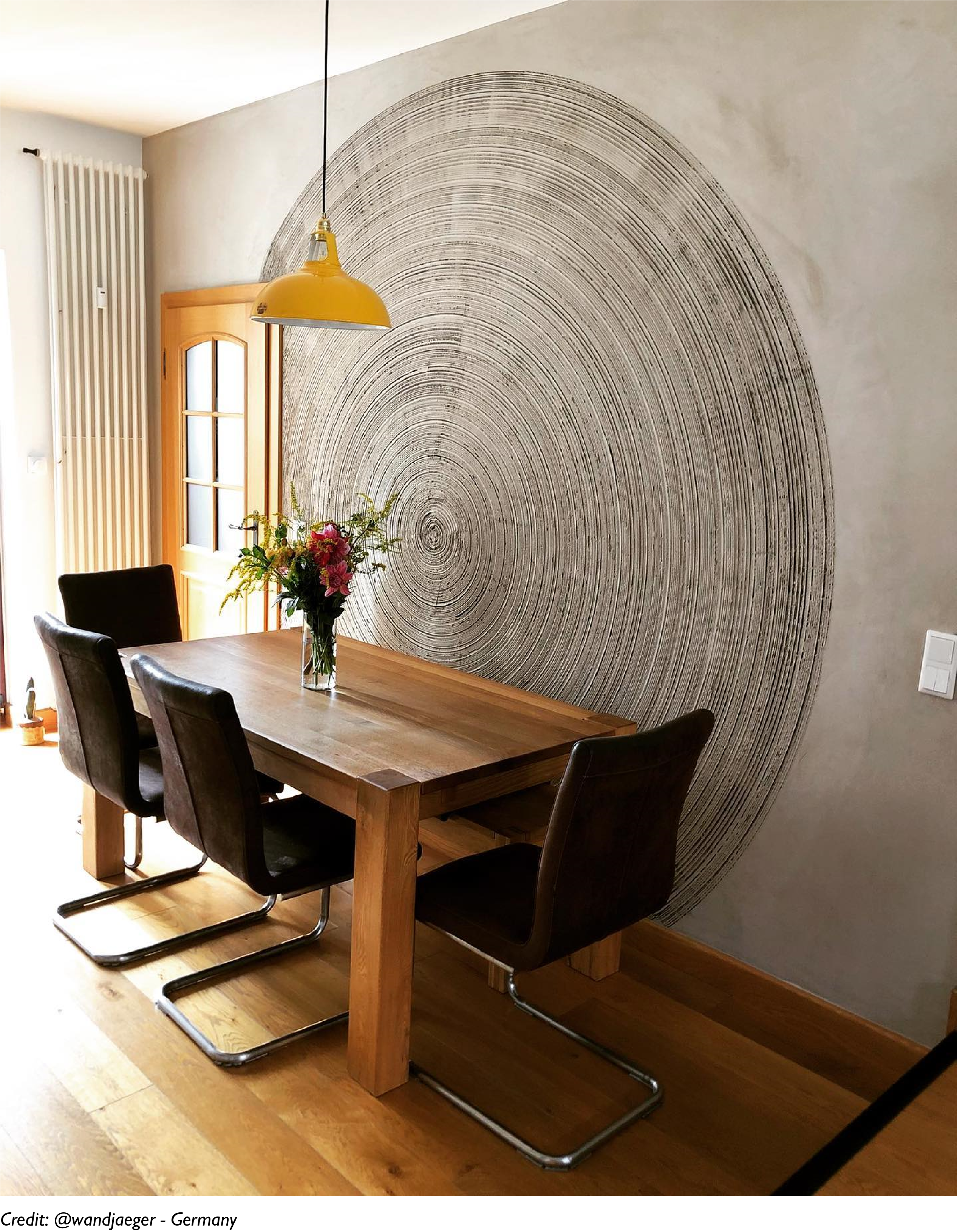 A Large Yellow lampshade hanging over a table in a dining room