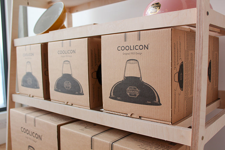 three small Coolicon product boxes stocked on a plywood frame above 2 larger product boxes.