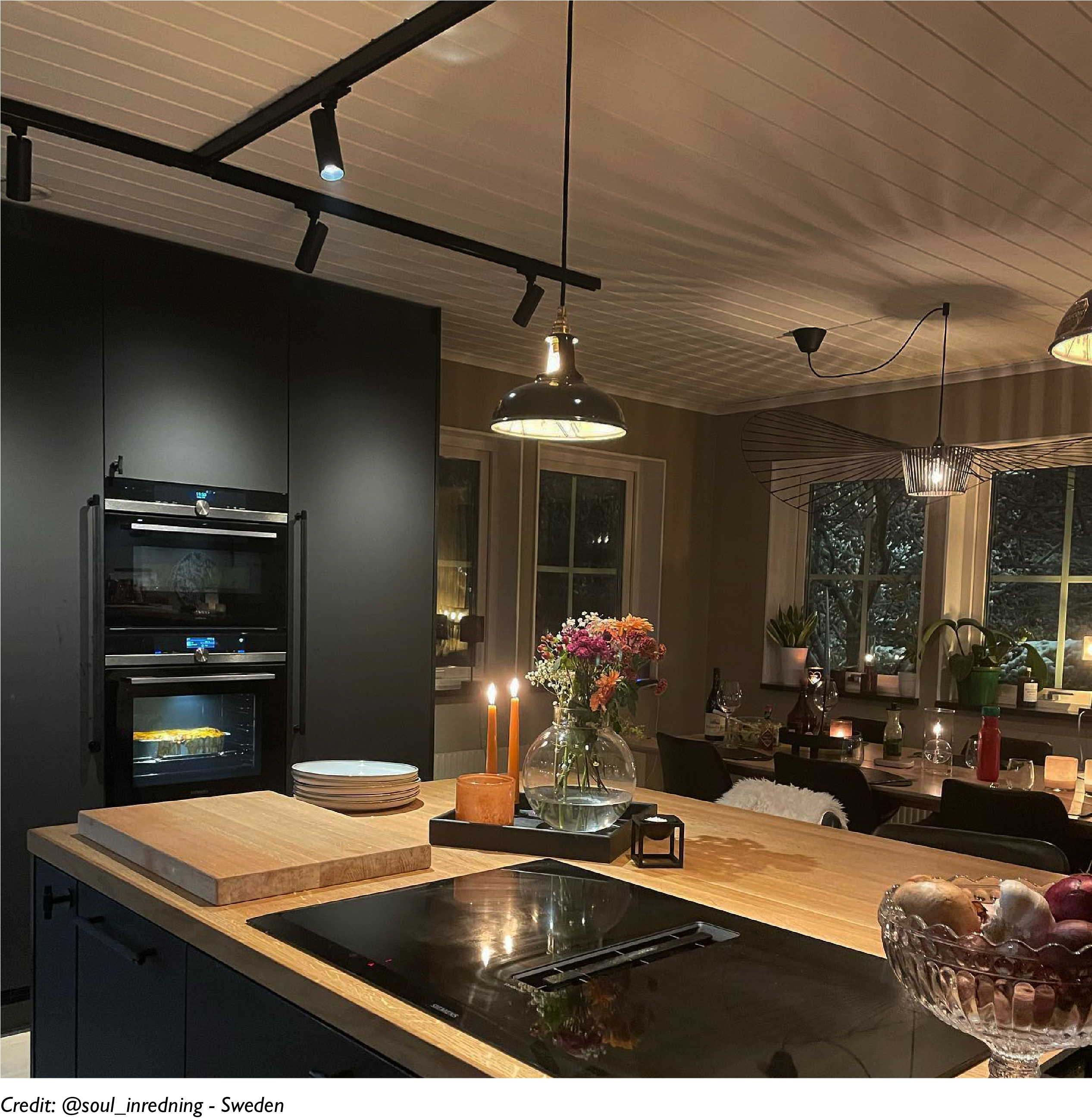 Two Northern Line Black lampshades hang over a kitchen cooker in an open plan kitchen