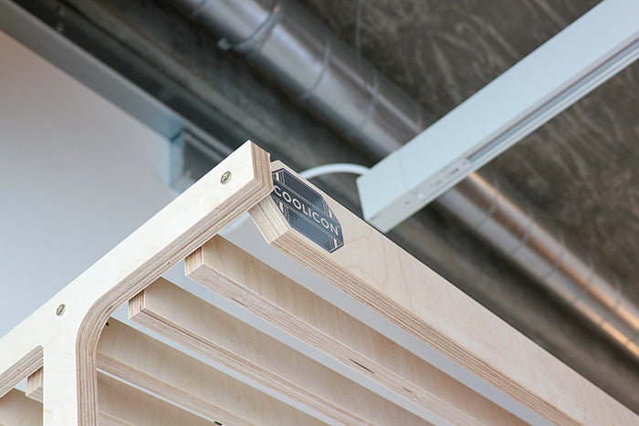 Looking up at a black vinyl coolicon badge logo applied onto a plywood frame point of sale display stand.