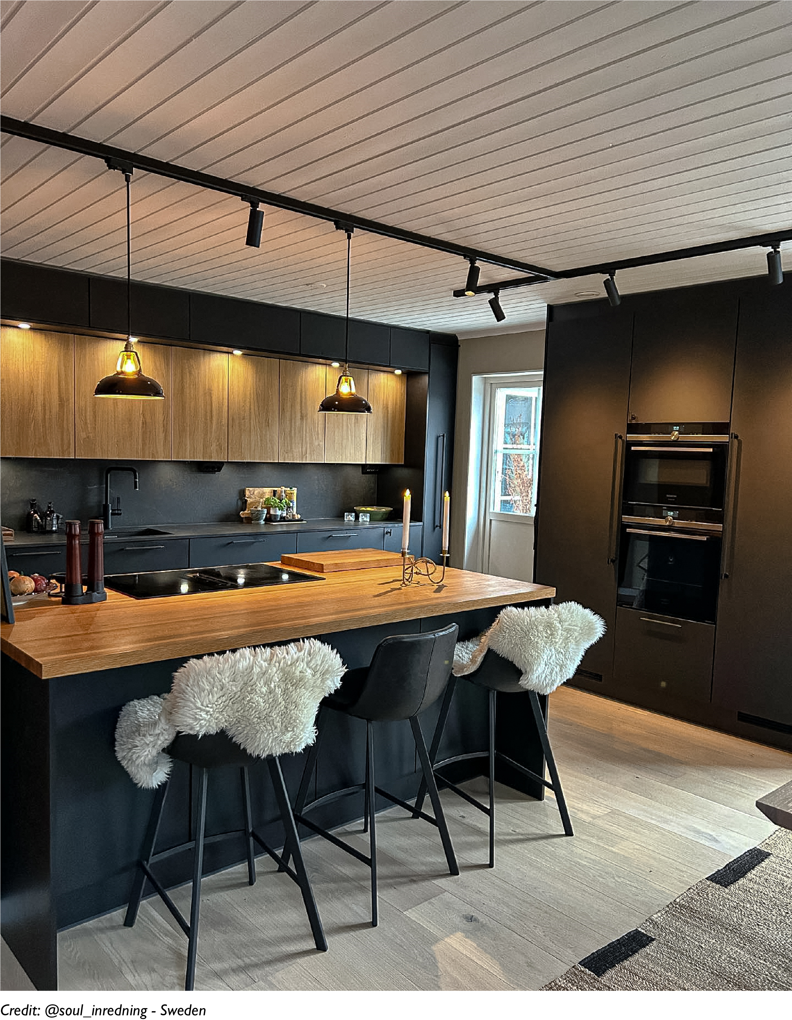 Two Pewter lampshades hanging over a wooden kitchen island in a modern kitchen