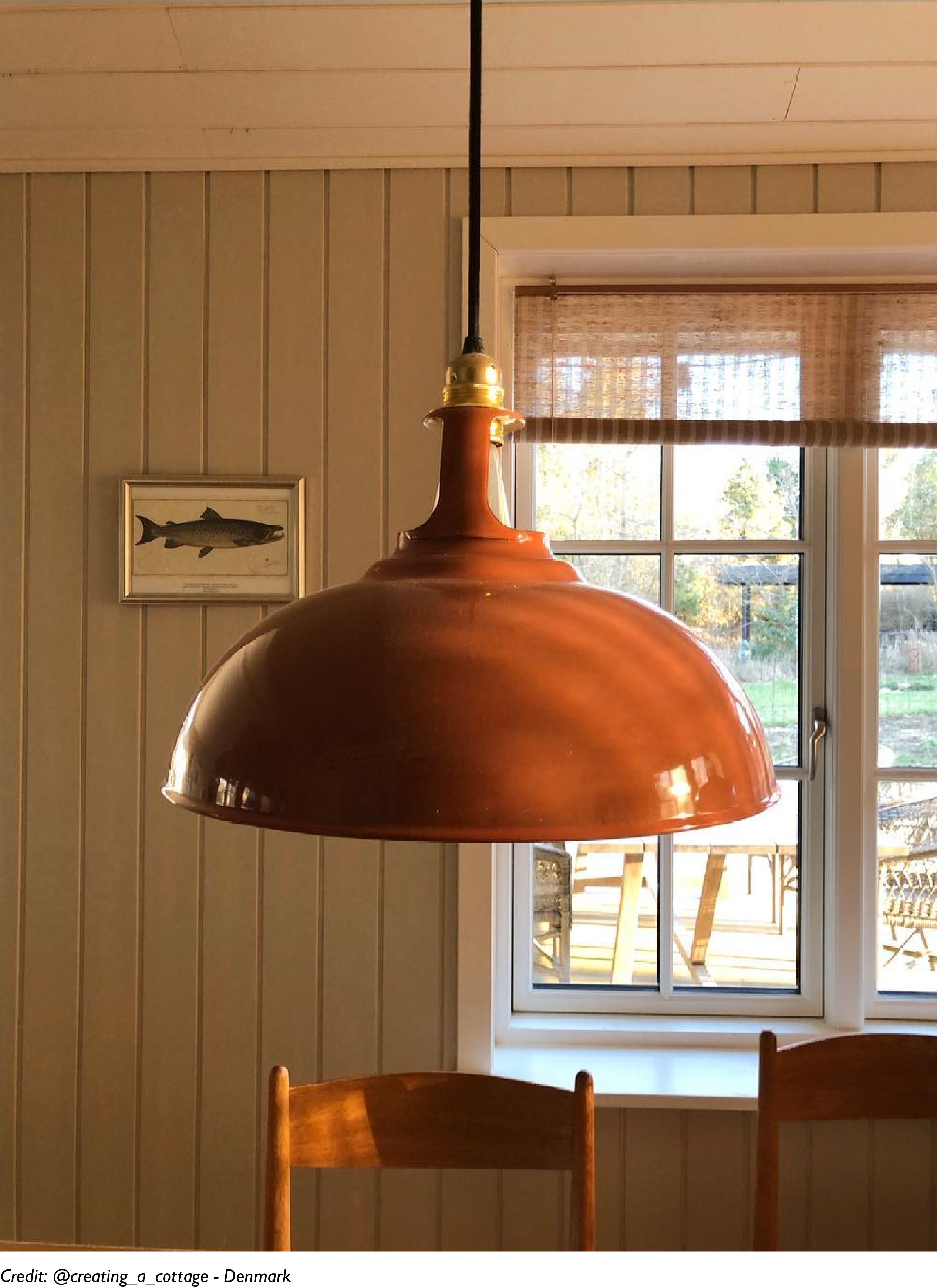 A Large Terracotta lamp hangs in a Nordic style interior
