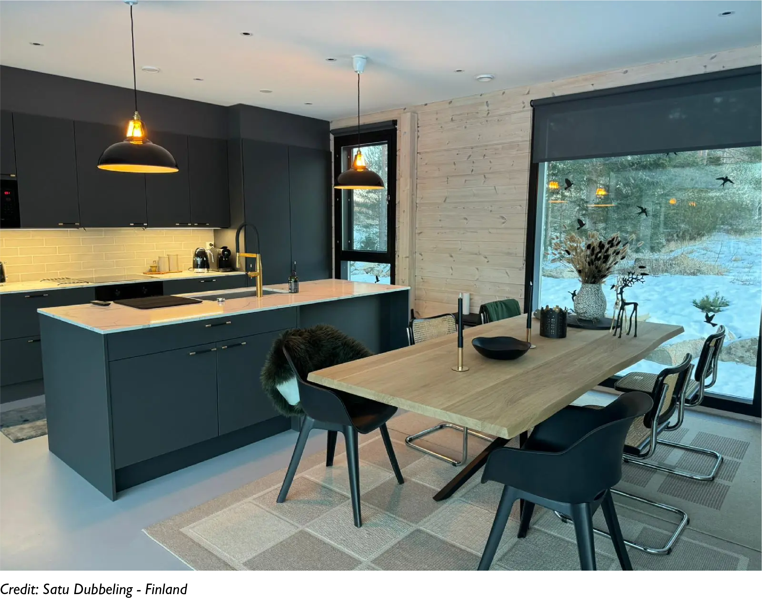 2 Large Jet Black lampshades hanging over a kitchen island and sink in an open-plan room