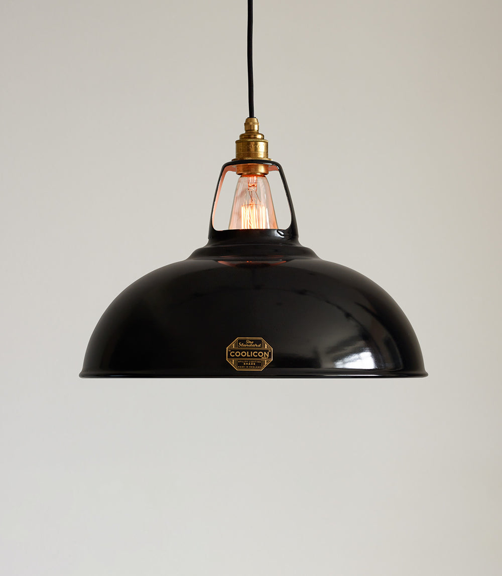 A Large Jet Black lampshade hanging over a cream background