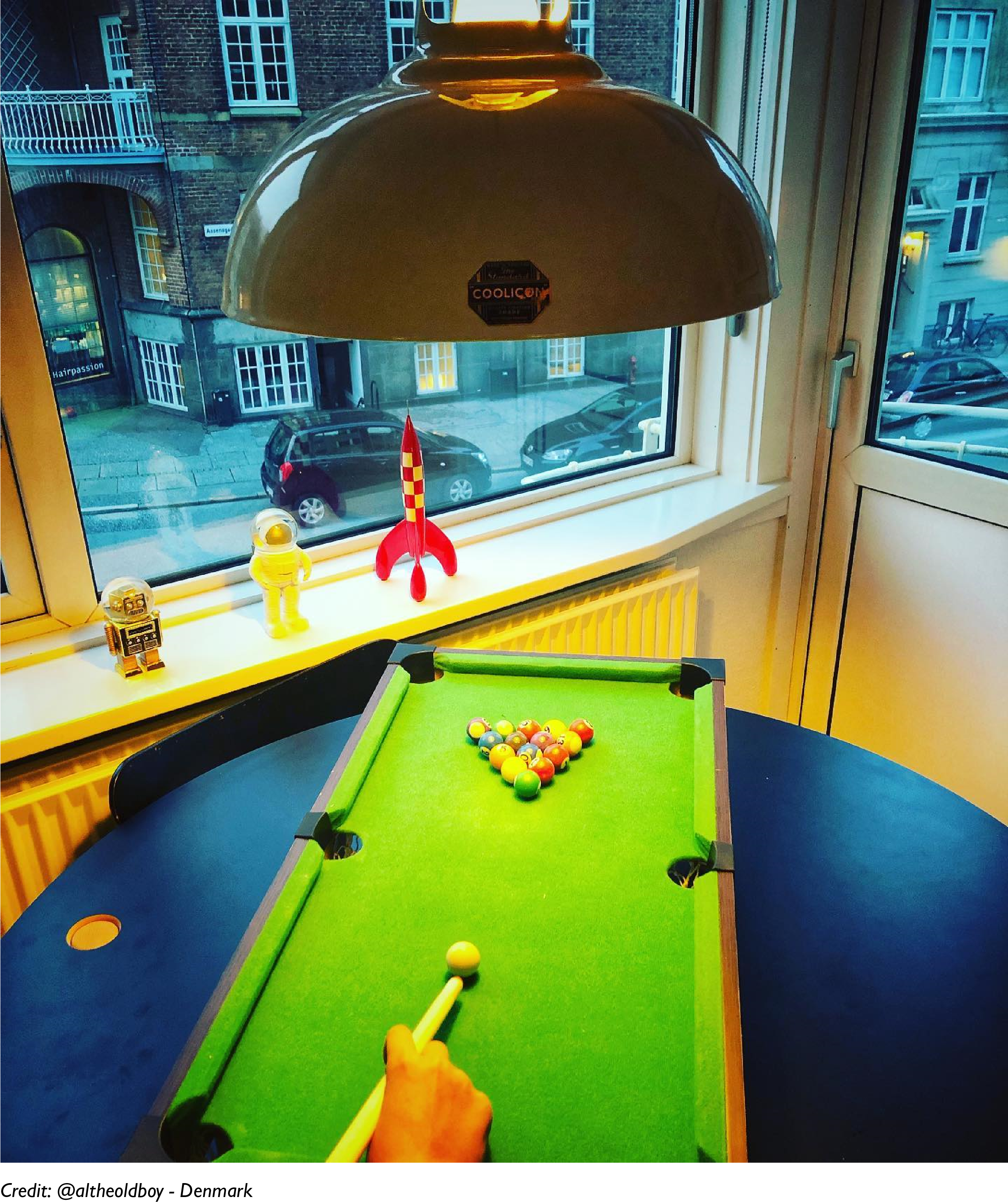 A Large Latte lampshade hangs over a pool table