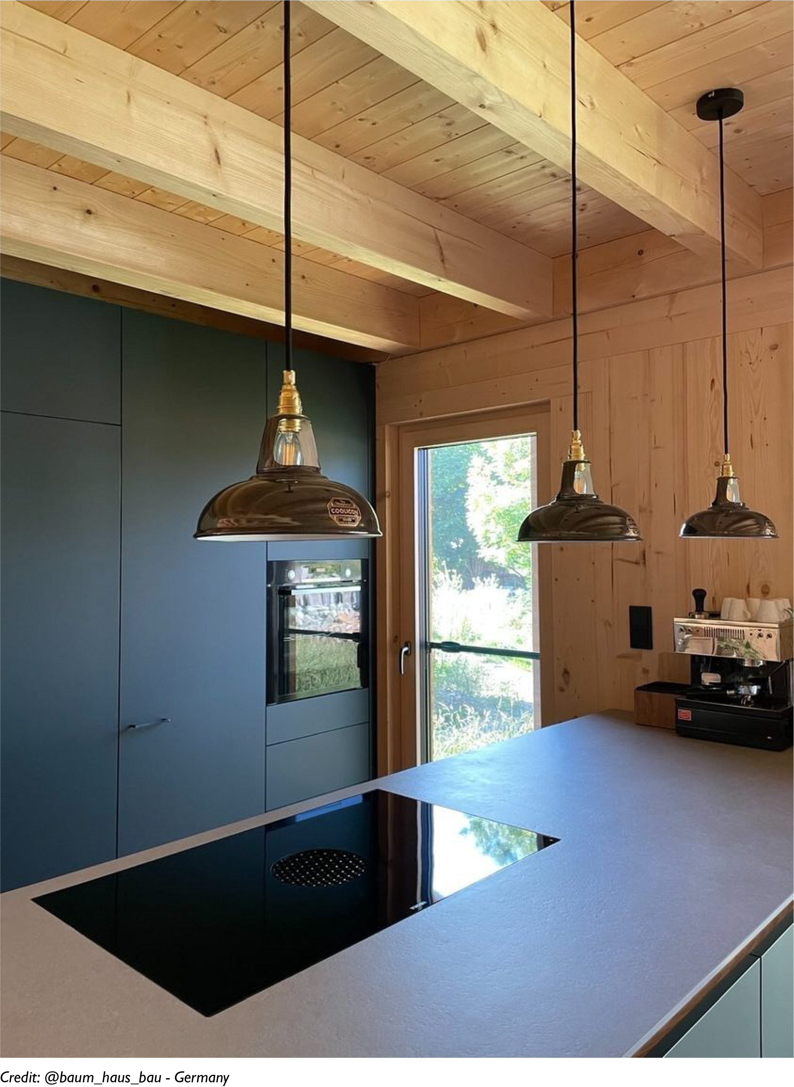 Three Pewter lampshades hang over a concrete island in a kitchen