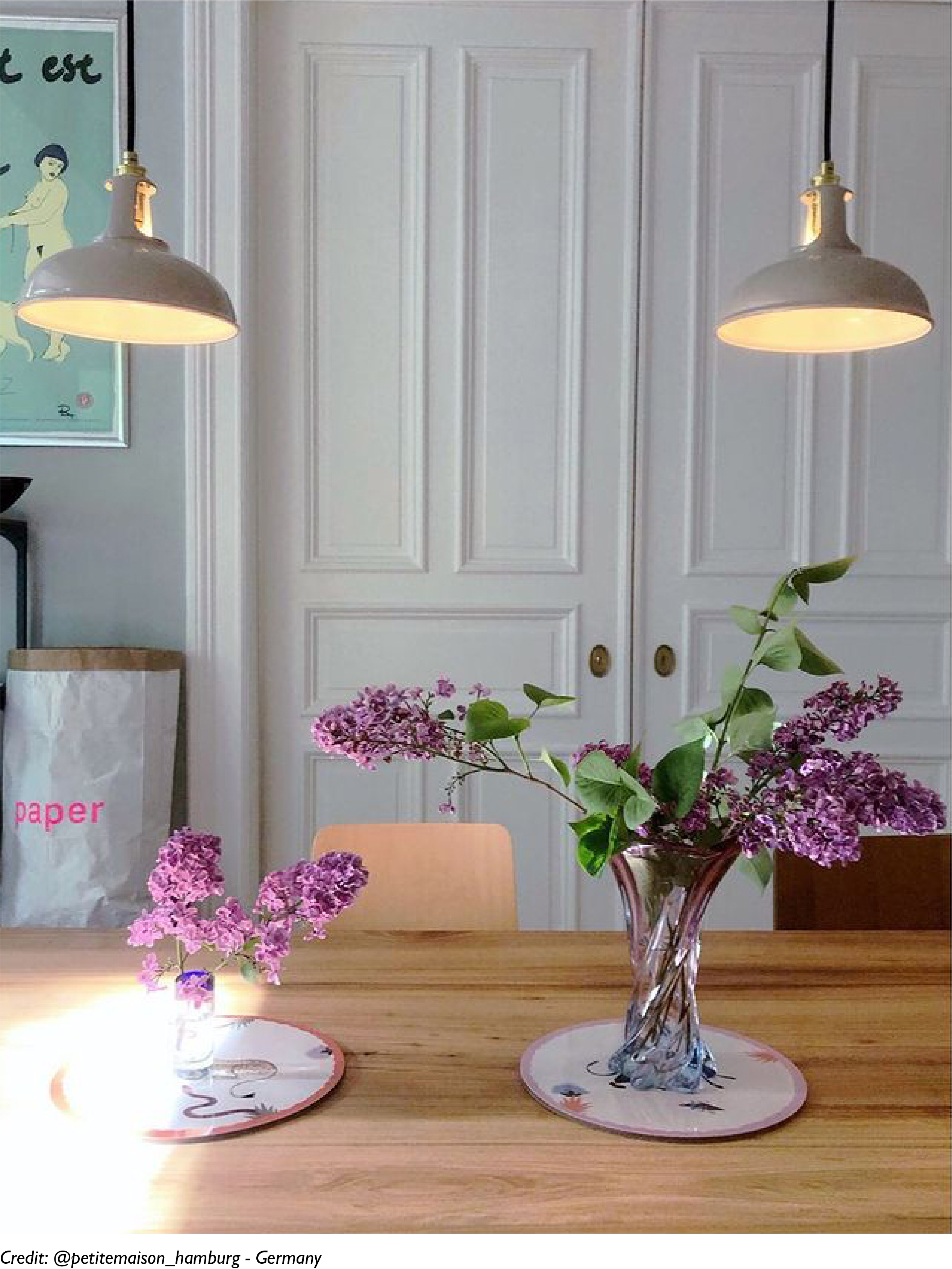 Two Latte lampshades hanging over a dining table with a bouquet of flowers