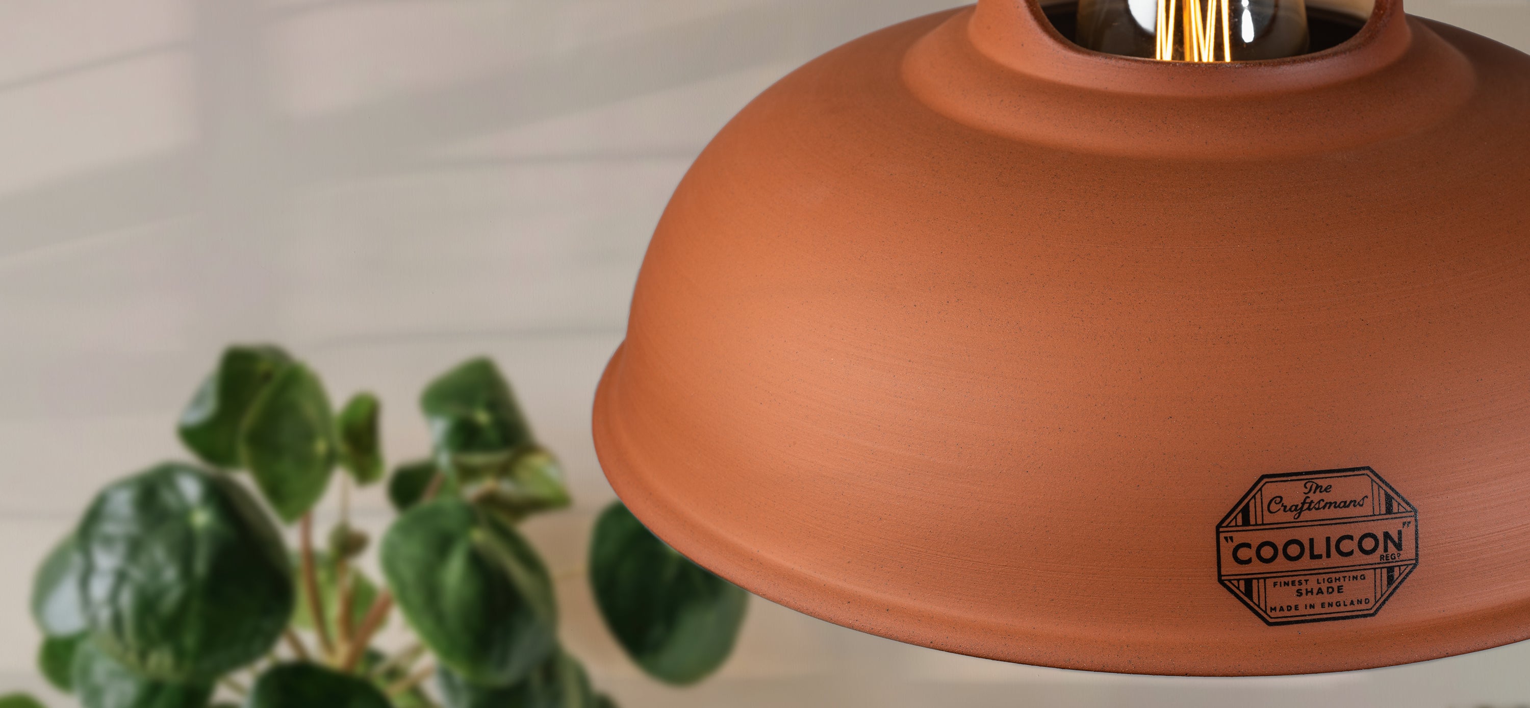 A close up of the front of a Natural Terracotta shade, showing the details of the badge as well as the texture on the shade