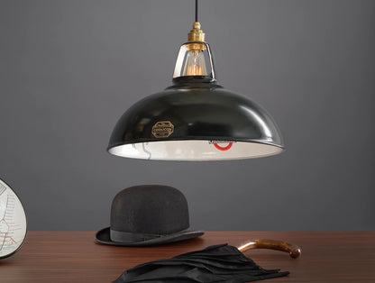 A Large Northern Line shade above a wooden table. Below it is a black bowler hat and a black umbrella, and on the left a cropped section of the Original Northern Line shade