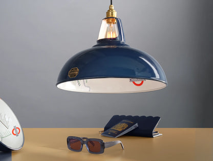 A Large Piccadilly Line Blue shade above a table. Below it is a blue purse, a blue British passport and a pair of blue sunglasses