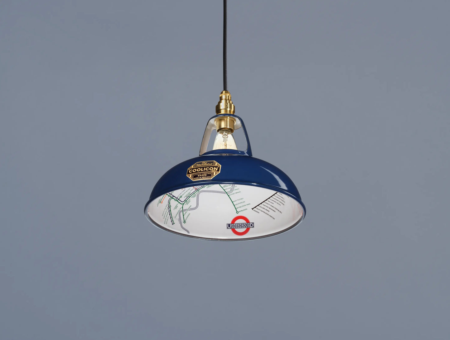 An Original Piccadilly Line Blue shade hanging over a blue background