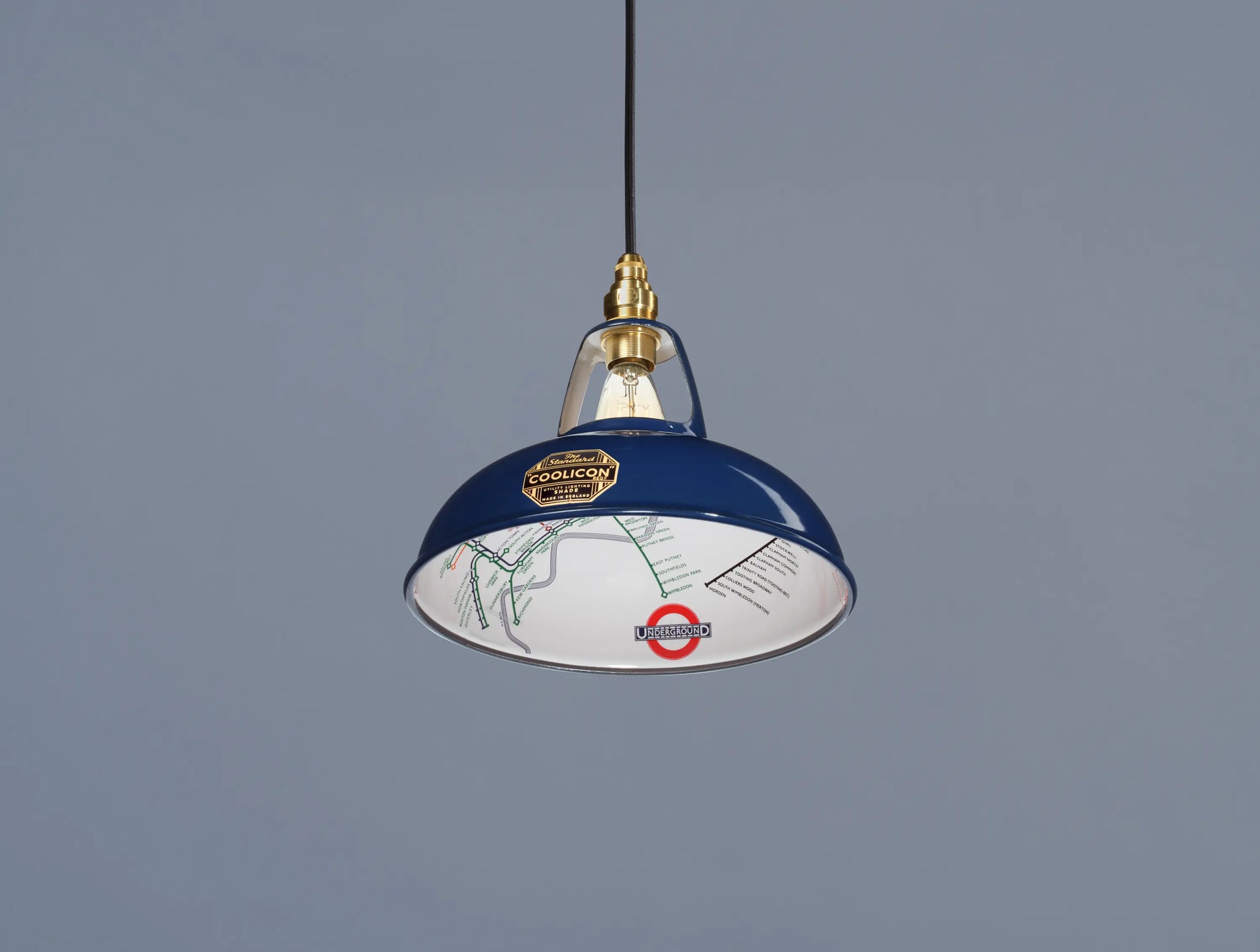 An Original Piccadilly Line Blue shade hanging over a blue background